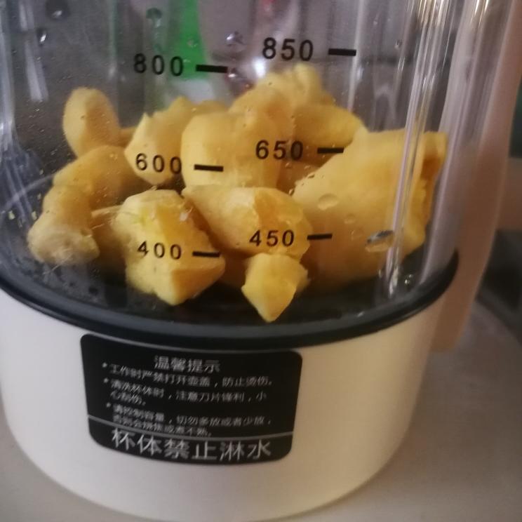 工业级低速螺旋榨汁机工作场景:不锈钢料斗中投入去皮老姜块,出汁口持续流出浓稠、透亮、略带金黄色泽的姜汁,汁液表面有细微油性光泽。背景为洁净食品级操作台,温度计显示环境温度18℃,强调低温稳定萃取过程 老姜榨汁过程实拍:低速冷榨机出汁特写