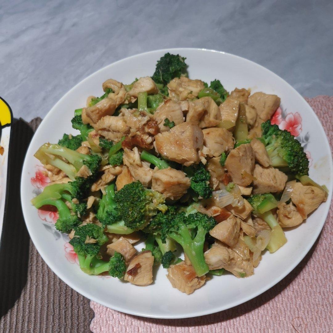 高清厨房实拍:不锈钢炒锅中呈现琥珀色羊肉丁(约1.5 cm见方)与翠绿西兰花花球(未焯水,保留完整花蕾)同炒,锅气升腾,表面微焦但无焦黑,辅以少量姜丝与枸杞点缀;背景为木质料理台,凸显家庭健康烹饪场景 西兰花羊肉家常快炒实拍图
