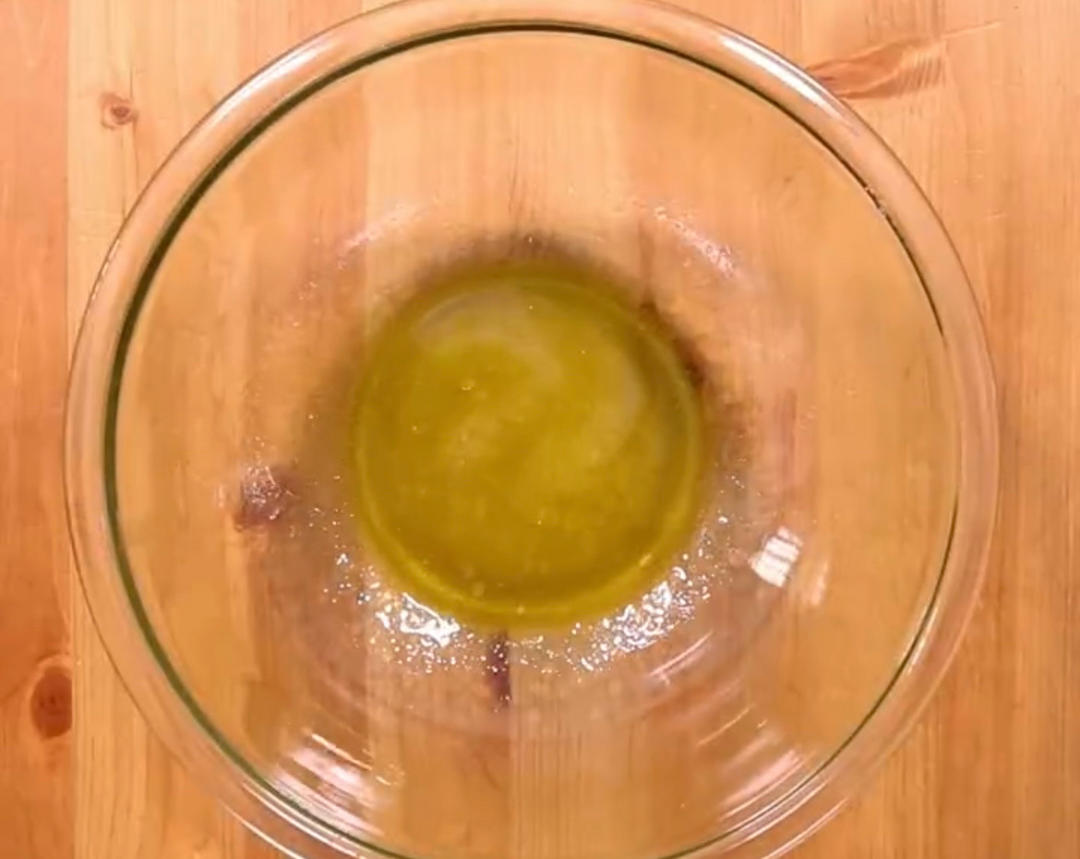 木质餐桌上并列摆放着多个透明玻璃油瓶,分别装有金黄色的大豆油、深色橄榄油、浅黄色葵花籽油,标签清晰可见,旁边放有一把量勺和新鲜蔬菜,营造健康饮食氛围 厨房中多种食用油瓶摆放对比图