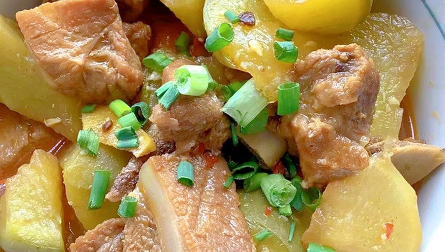 厨房操作台上摆放着老母鸡炖土豆的成品 dish，旁边配有米饭、筷子和汤勺，展示实际用餐场景