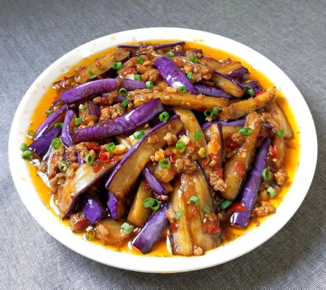 一幅简化的中国地图,华北(京津冀)、华东(江浙沪)和华中部分省份被高亮标记,表示红烧茄子的主要流行区域,地图上方写着‘红烧茄子流行分布图’,图标显示筷子夹起一块茄子,象征饮食文化传播 一张中国地图标注红烧茄子流行区域