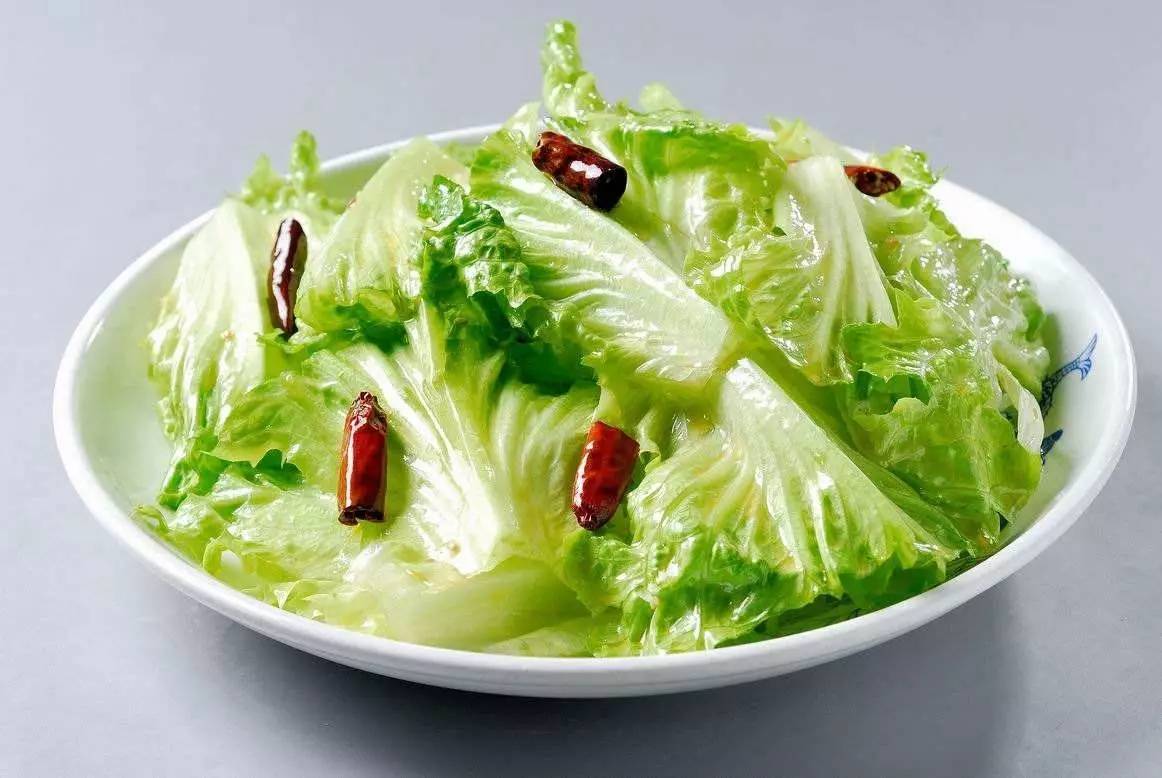 凉拌生菜现场拌制过程图:不锈钢盆中生菜饱满挺括,调味汁呈透亮琥珀色,筷子动作轻柔呈托举状,强调‘快拌不揉’手法,计时器精准记录12秒操作时长 家庭厨房操作台实景:不锈钢盆中盛放沥干后的翠绿生菜叶,旁边小碗盛有金黄色蒜香调味汁(可见浮油与蒜末粒),一双竹筷正在轻柔翻拌,背景虚化处可见计时器显示“00:12”