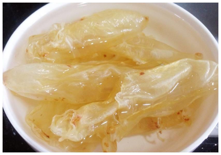 红枣牛奶炖花胶核心食材实拍:左为经冷水泡发24小时+蒸焖处理的鳘鱼肚,中为去核预煮的若羌灰枣,右为全脂巴氏杀菌鲜奶,三者比例精准对应后续步骤 红枣牛奶炖花胶食材特写:玻璃碗中整齐排列6片泡发好的金黄鳘鱼肚、12颗去核若羌灰枣、一盒全脂巴氏鲜奶并列摆放,背景为木质料理台