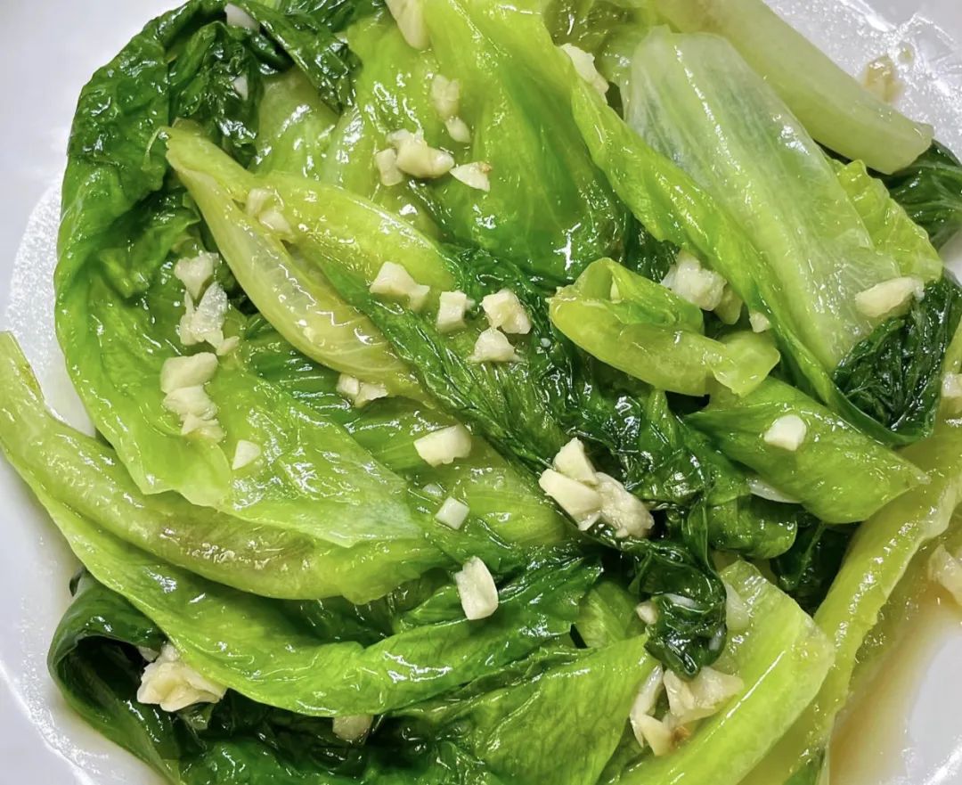 展示一道炒制的蒜香生菜,色泽翠绿,香气扑鼻 炒生菜配蒜末