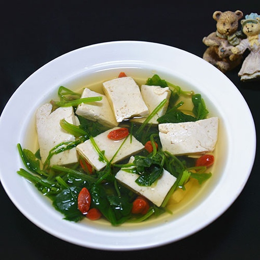 俯拍美食图:白瓷碗盛放焯水菠菜豆腐丝拌豆浆羹(菠菜+嫩豆腐+温豆浆调制),表面撒白芝麻与枸杞;旁配营养标签卡,清晰标注'草酸残留:12.3 mg/份''可利用铁:1.8 mg/份''植物钙:48 mg/份' 营养师指导下的菠菜豆浆早餐成品