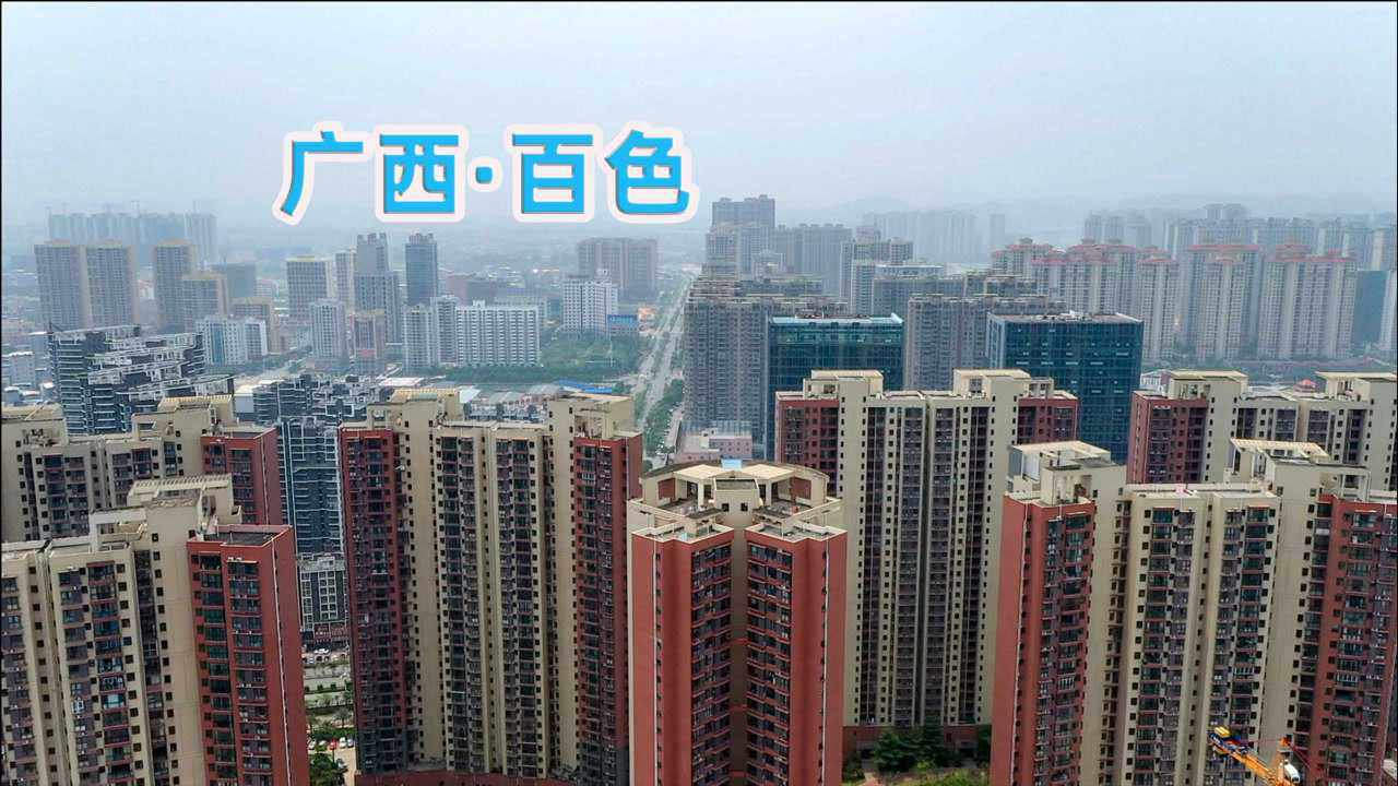 广西百色市德保县山区牧场航拍图,展示连绵起伏的丘陵地貌,绿草如茵的天然牧场,成群的德保矮马在阳光下悠闲吃草,背景可见典型的喀斯特地貌山峰,远处有农户木屋点缀其中 德保县山区牧场全景