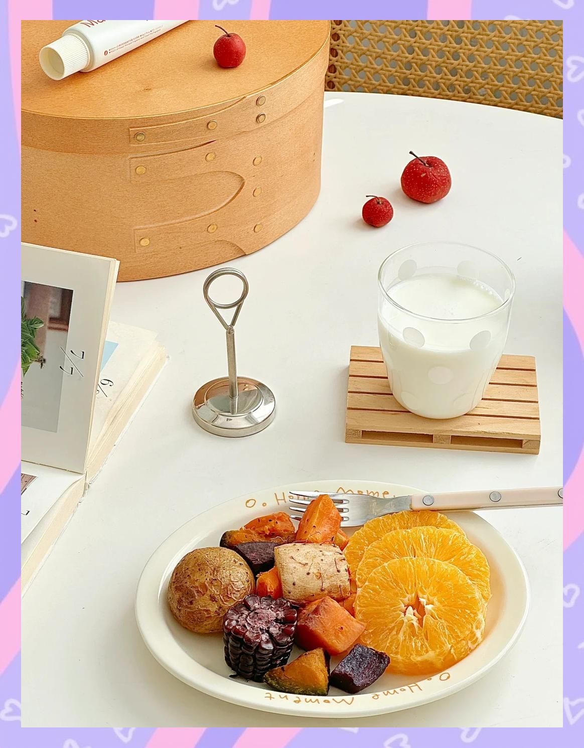 一张温馨的家庭餐桌照片,中央摆着一个白色瓷盘,盛放着色彩鲜艳的水果萝卜切片拼盘,周围点缀薄荷叶和柠檬角,旁边有一杯橙汁和全麦面包,营造出健康早餐氛围 家庭餐桌上的水果萝卜拼盘