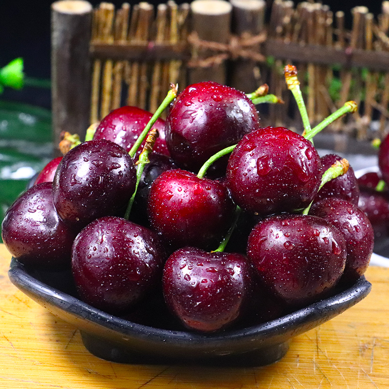 一碗透明玻璃碗中盛放着切块的橙黄色木瓜与鲜红车厘子,点缀几粒黑色奇亚籽,旁边放一把不锈钢勺子,背景虚化,强调食物的天然与健康属性 木瓜车厘子水果沙拉成品图