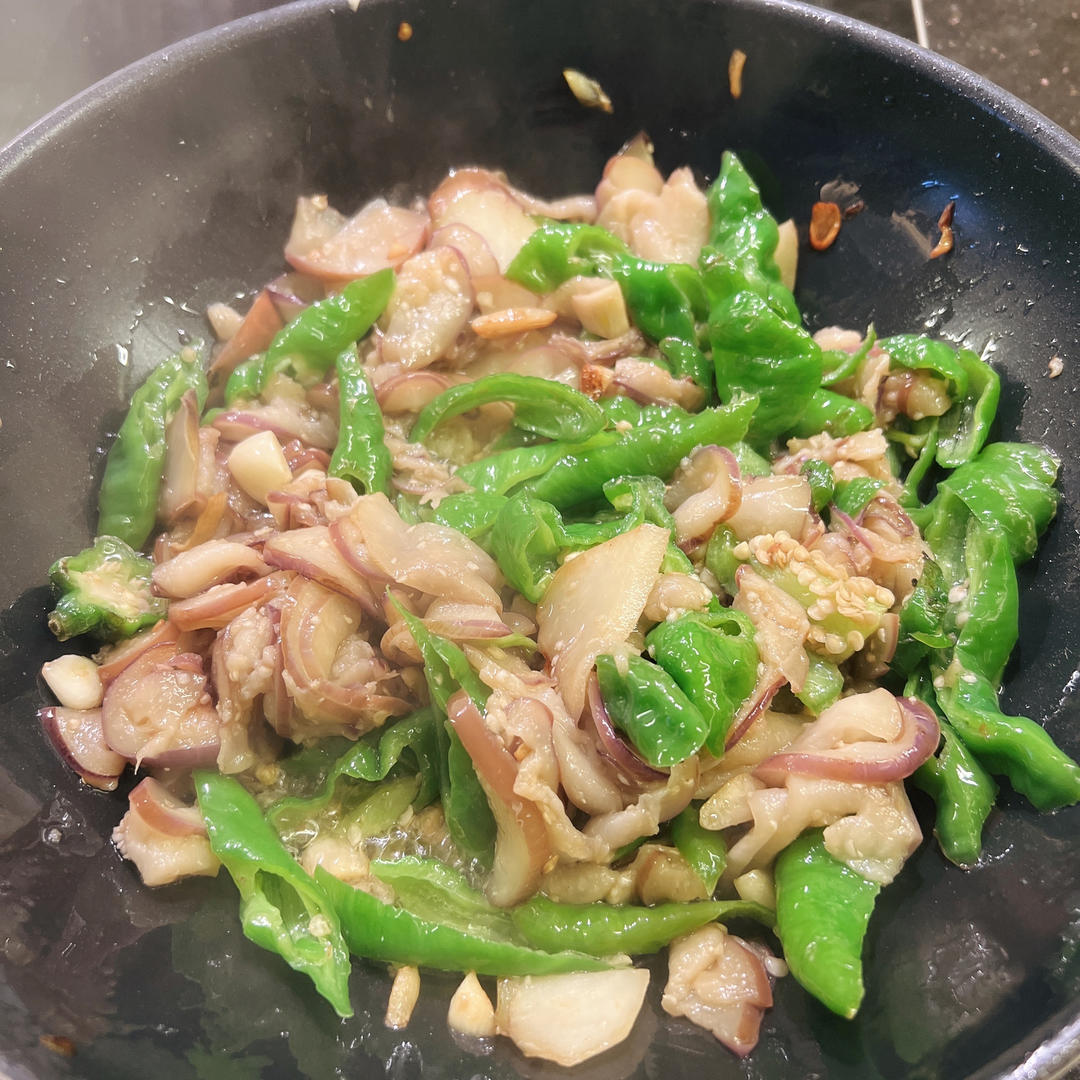 展示花菜与茄子在锅中翻炒的过程,体现烹饪步骤 花菜茄子炒制过程图