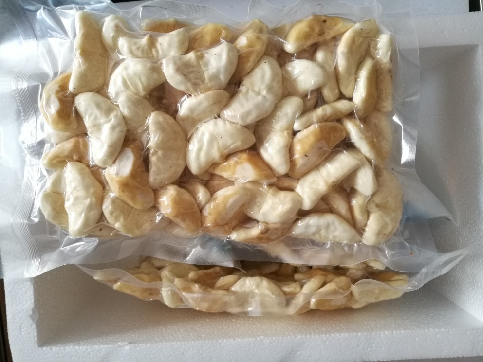 一个透明塑料保鲜盒内装有去皮切块的苹果,果肉略有轻微褐变,盒子盖紧放置于家用冰箱冷藏格中,周围有其他蔬菜水果,温度显示为4°C 家庭冰箱中存放切块苹果的保鲜盒特写