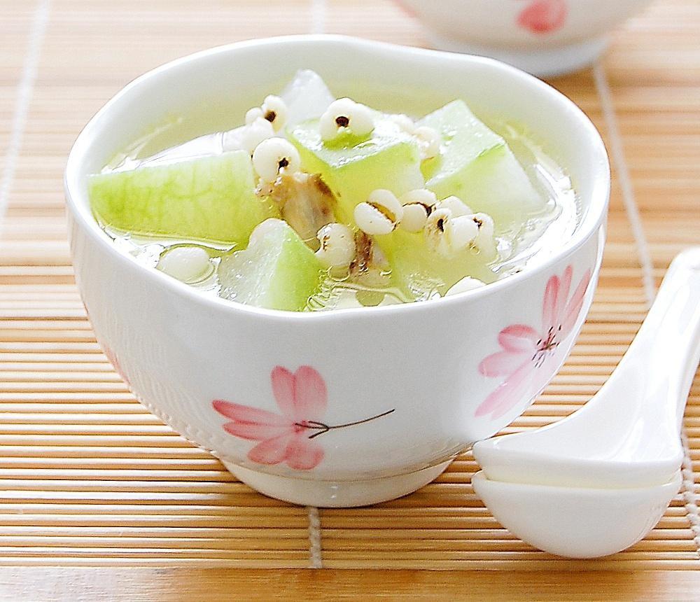 一口深色陶瓷砂锅置于灶台上,锅中可见冬瓜皮与薏米、赤小豆、红枣等食材共煮,蒸汽袅袅升起,展现传统中式养生汤品的烹饪过程 冬瓜皮与其他食材一同放入砂锅中慢炖的场景