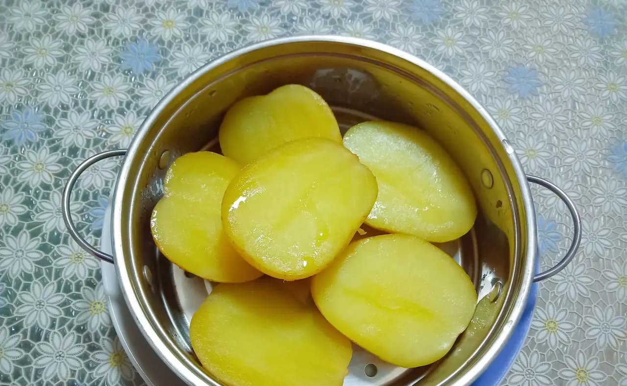 厨房中正在蒸制的整颗土豆