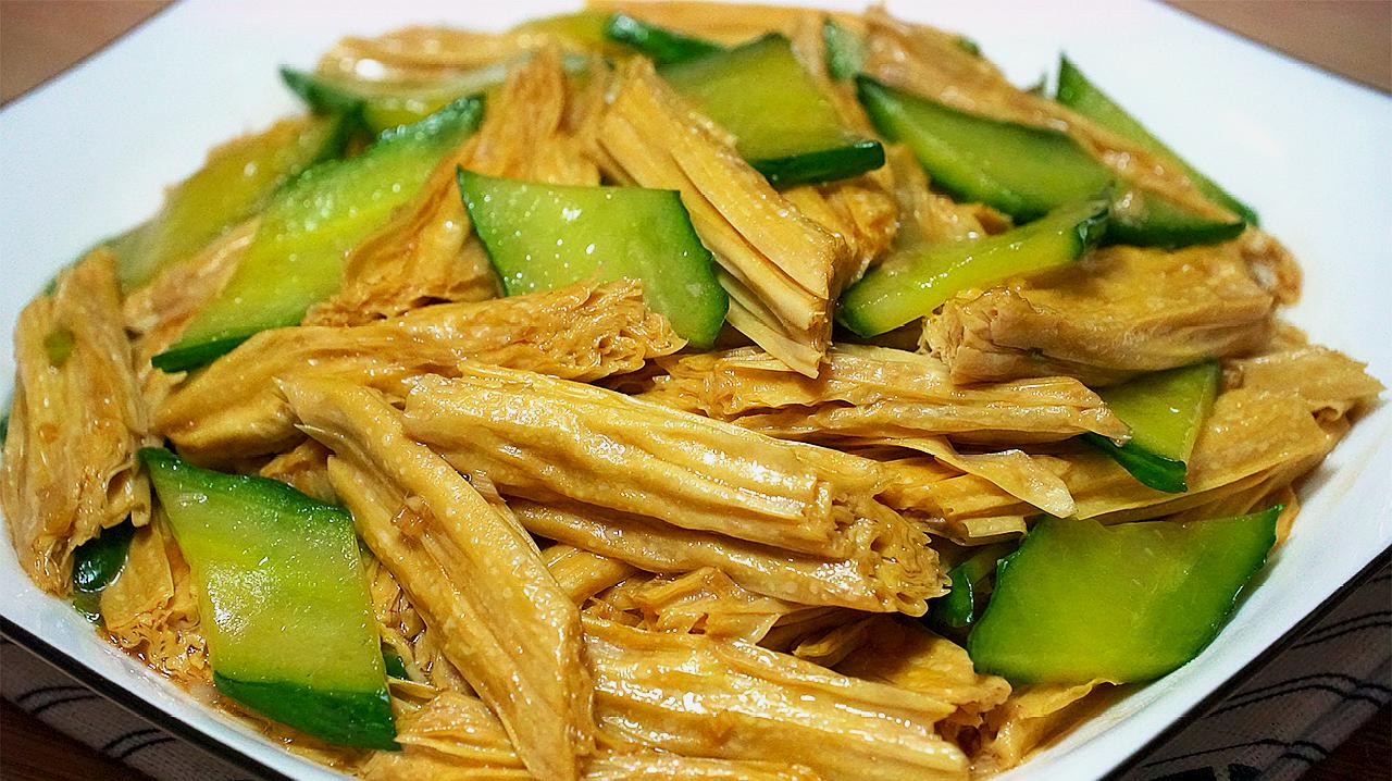 一盘清炒竹笋配豆腐,竹笋呈淡黄色片状,豆腐为白色块状,点缀青葱,旁边有一杯清水和柠檬片,象征健康搭配 竹笋搭配菜肴示意图