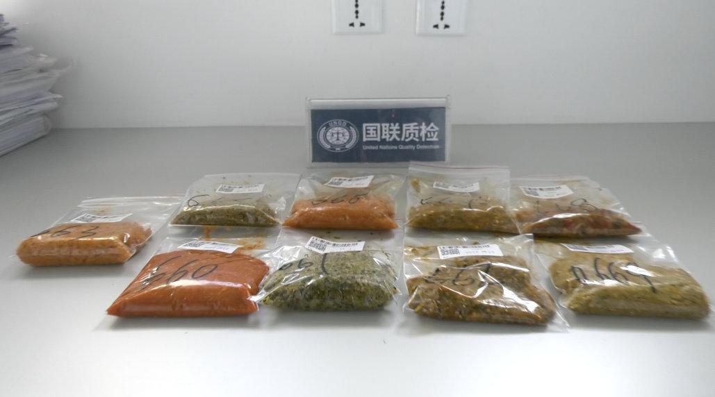 一名技术人员正在使用标准容重测定仪测量大豆样品的容重。设备包括漏斗、容积筒和电子天平,背景为实验室环境,桌上摆放多个大豆样品袋,标签清晰可见 大豆容重测量示意图