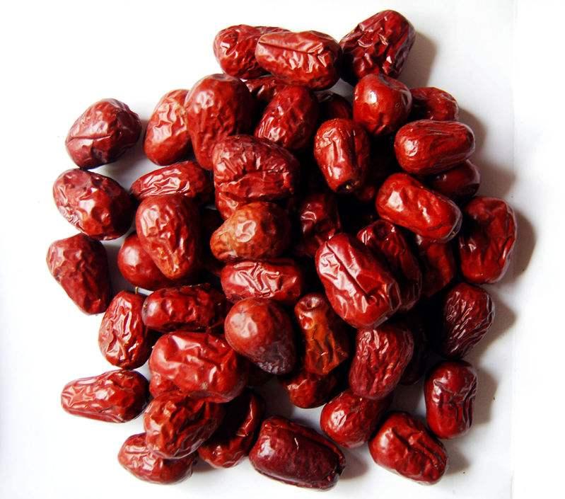 特写展示枣皮的自然纹理,表面有轻微褶皱和光泽感,颜色为深红色,背景为白色,突出产品细节 枣皮细节图