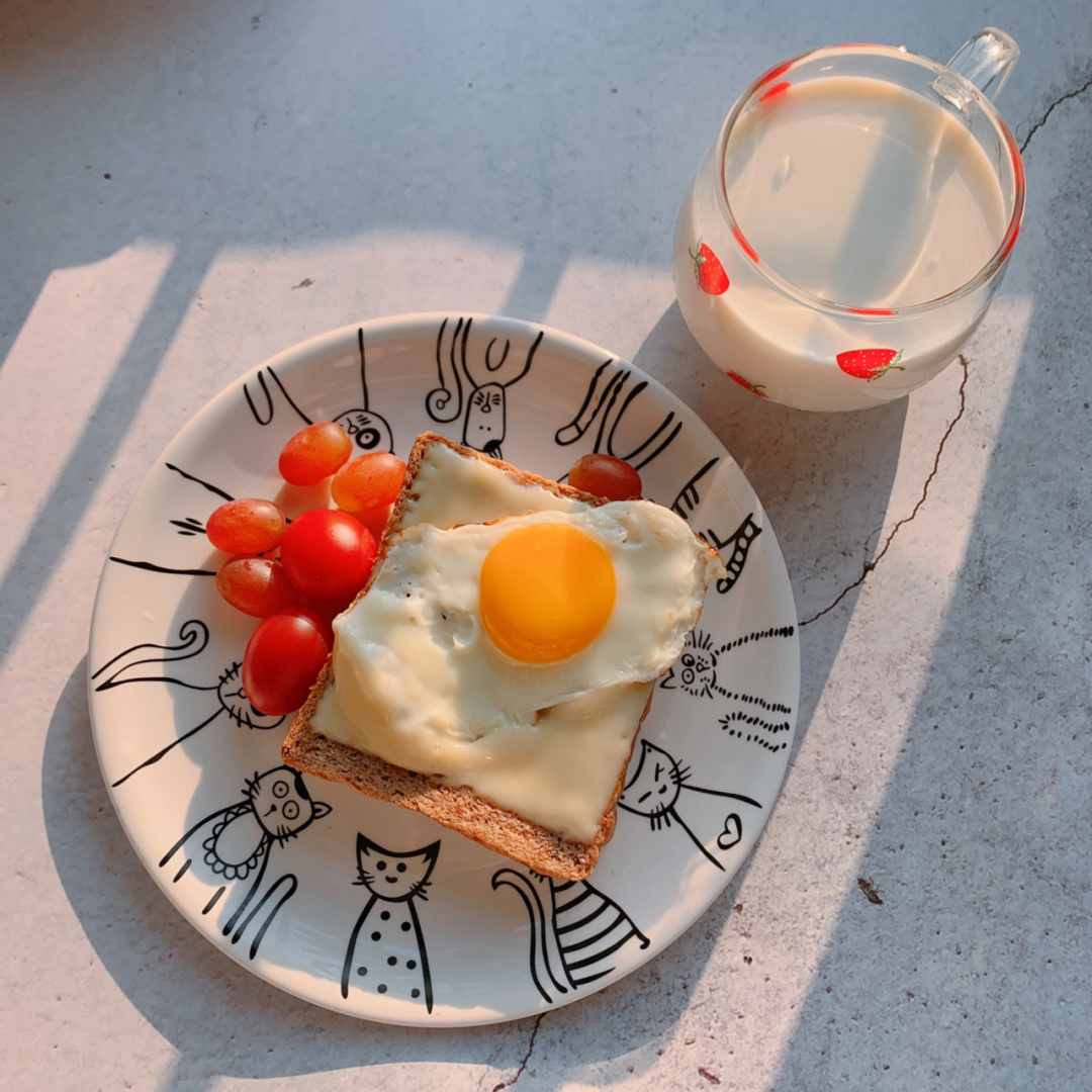 早餐搭配示意图：煎蛋、牛油果吐司、橙子和一杯牛奶