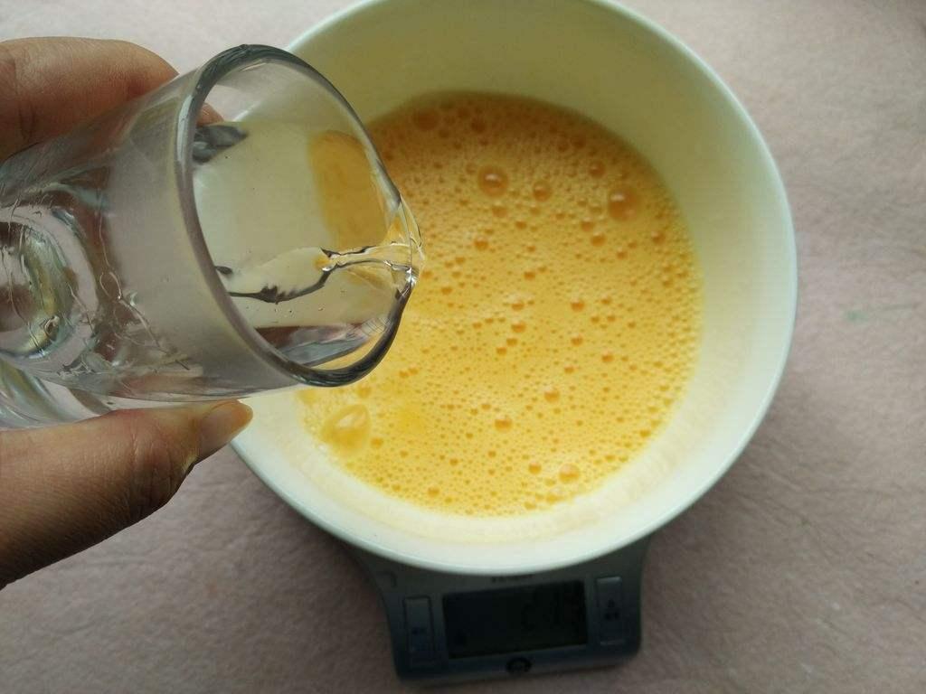 一位女性正在明亮现代的厨房中将鸡蛋从纸盒中取出,逐一放入白色瓷碗,并用手机记录数量,桌面上放有便签本、笔和数字厨房秤,体现日常生活中的实用场景 家庭主妇在厨房清点鸡蛋并记录数量