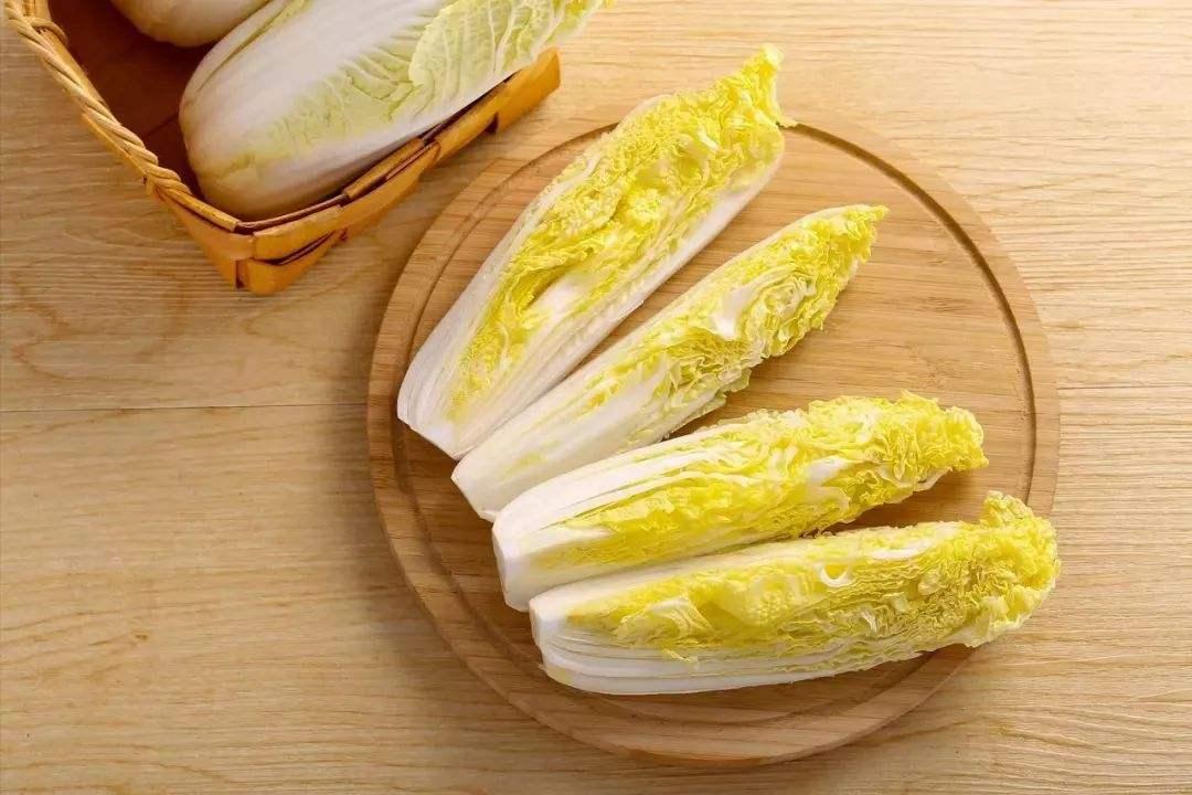 一张木制餐桌上摆放三盘不同做法的娃娃菜:左侧为清炒娃娃菜(油亮翠绿),中间为上汤娃娃菜(带汤汁配瓷勺),右侧为凉拌娃娃菜(装在玻璃碗中,撒有芝麻和辣椒圈),背景虚化中有筷子和茶杯,营造温馨用餐氛围 图片描述