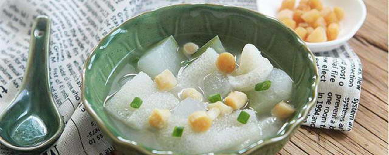 一碗金黄色调的冬瓜鸡汤,汤面光洁无浮油,可见完整的干贝颗粒和嫩白冬瓜块,枸杞点缀其中,背景为木质餐桌与瓷碗 干贝冬瓜鸡汤特写