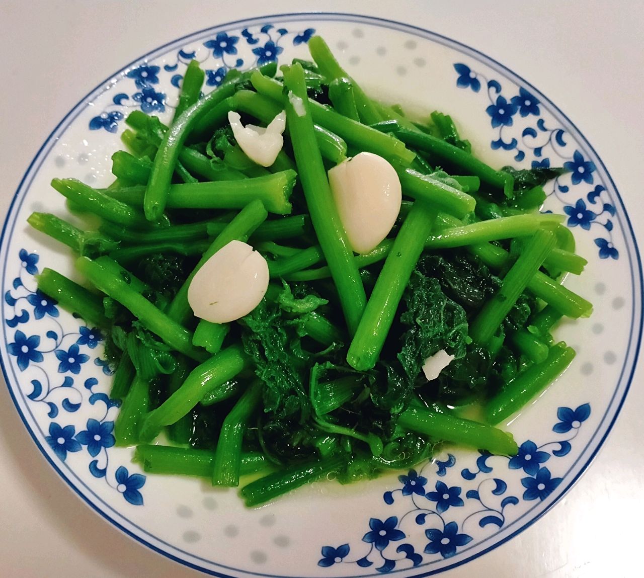 家庭厨房中正在烹饪菜心的场景