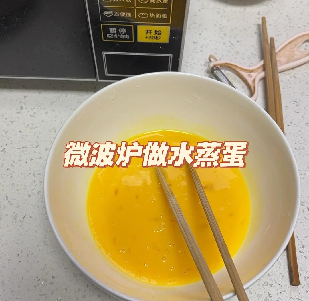 一张木质餐桌上摆放三种微波炉制作的鸡蛋美食:左侧是切开的水煮蛋,中间是晶莹剔透的蒸蛋羹,右侧是金黄流心的煎蛋;背景虚化处可见微波炉和调料瓶 微波炉鸡蛋美食成品拼盘图