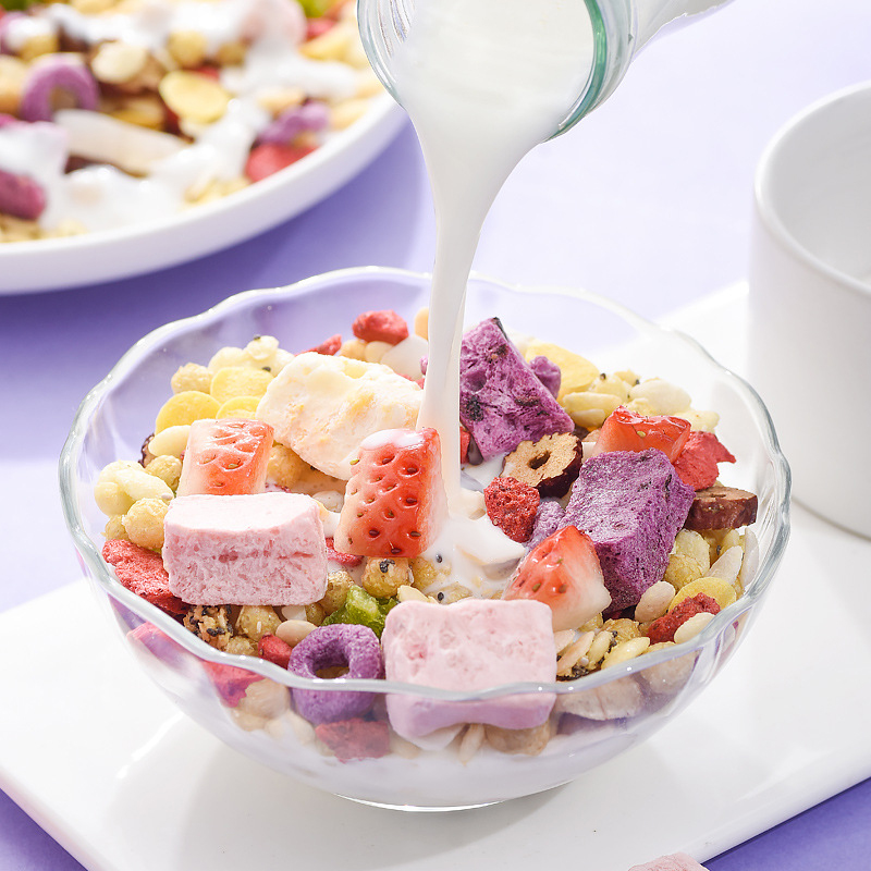 一个透明玻璃瓶装的姬松茸芦笋液正被倒入浅色玻璃杯中,周围摆放全麦面包、鸡蛋、牛油果和橙汁,展现健康早餐搭配场景,光线柔和温馨 家庭厨房中将姬松茸芦笋液倒入玻璃杯并与常见早餐食物摆放在一起的场景图