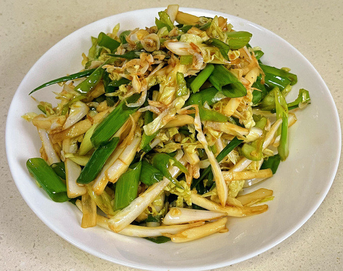 白菜洋葱炒制完成装盘效果:青白白菜条与紫红洋葱丝比例约3:2,分布均匀、根根分明,表面浮着薄层琥珀色油光,撒有现磨白胡椒粒与熟芝麻,盘沿摆柠檬角与香葱段,背景为浅灰亚麻布 成品装盘特写:翠绿白菜条与紫红洋葱丝交错铺陈于白瓷圆盘中,油润不腻,撒有少许金黄芝麻与翠绿葱花,盘边点缀两片鲜柠檬角,整体色彩明快、质感分明