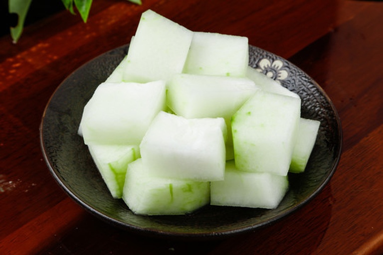 一张餐桌上的三道冬瓜菜品拼盘:左侧是清炒冬瓜片,中间是乳白色的冬瓜虾皮汤配汤匙,右侧是浅盘中的凉拌冬瓜丝,背景为竹制餐垫和陶瓷碗碟,整体风格清新自然 冬瓜多种做法拼盘图