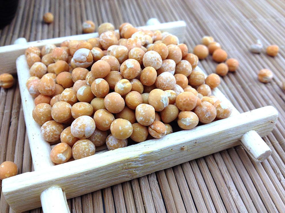 市场摊位上陈列的去皮白豌豆与成品豌豆黄对比展示