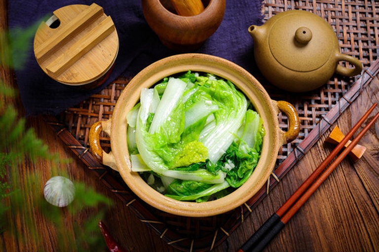 中式厨房场景摄影:一张原木料理台,焦点落在一只清代风格青花瓷炖盅内,盛有约八分满的冬笋炖鸡汤;汤体澄澈透光,可见悬浮的细密油脂星点与三片厚约0.5cm的冬笋片,笋片呈半透明乳白,纹理细腻,边缘柔韧微卷;盅旁置竹制汤勺与一小碟碧绿香葱末,背景虚化处隐约可见窗棂与腊梅枝 江南传统冬笋烹饪场景:青花瓷锅中慢炖的冬笋老母鸡汤,汤色清亮微黄,浮着细小金油星,几块半透明冬笋片沉于汤底,表面撒少许嫩葱末