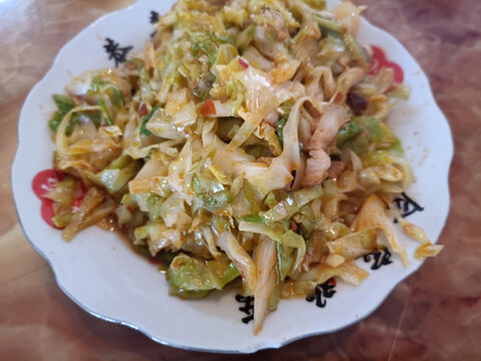 展示牛心包菜炒制后的成品图,色泽鲜亮,配以肉片和调料,诱人食欲 牛心包菜烹饪后的成品图