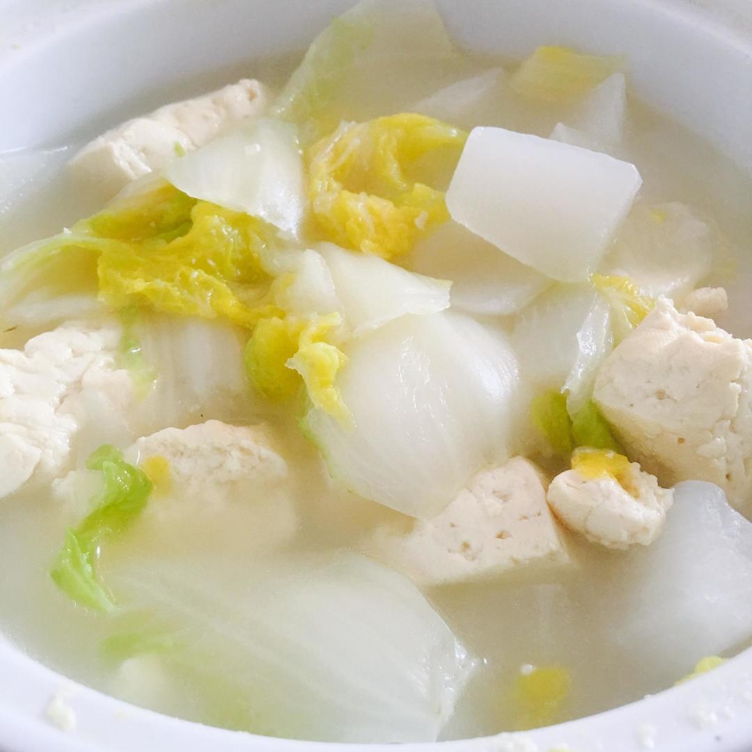 现代中式餐桌上摆放三道蔬菜菜肴:一碗炖大白菜豆腐汤、一盘清炒上海青、一份凉拌紫白菜丝,旁边配有米饭与主菜,体现多样化蔬菜摄入理念 家庭餐桌搭配实景图