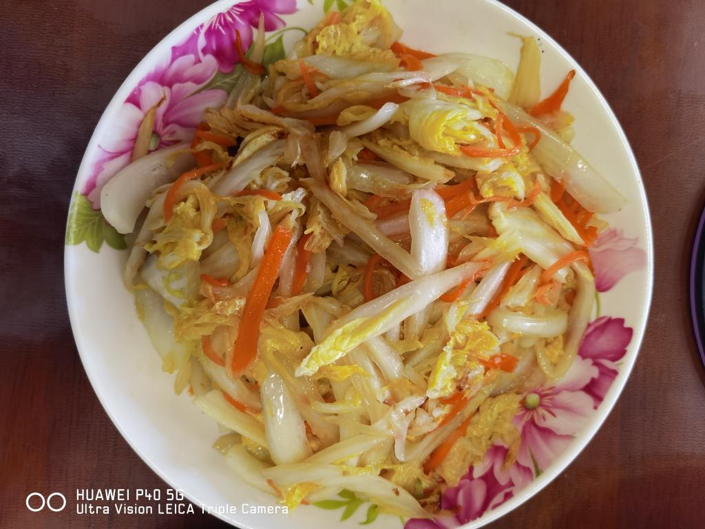 胡萝卜油菜快火清炒过程实拍,强调‘短时高温’工艺特征与成品色泽鲜活度 家庭厨房场景:中式炒锅内呈现胡萝卜片与油菜段正在快火翻炒,油光润泽、色泽鲜亮,锅气升腾,背景可见不锈钢调料罐与木质砧板