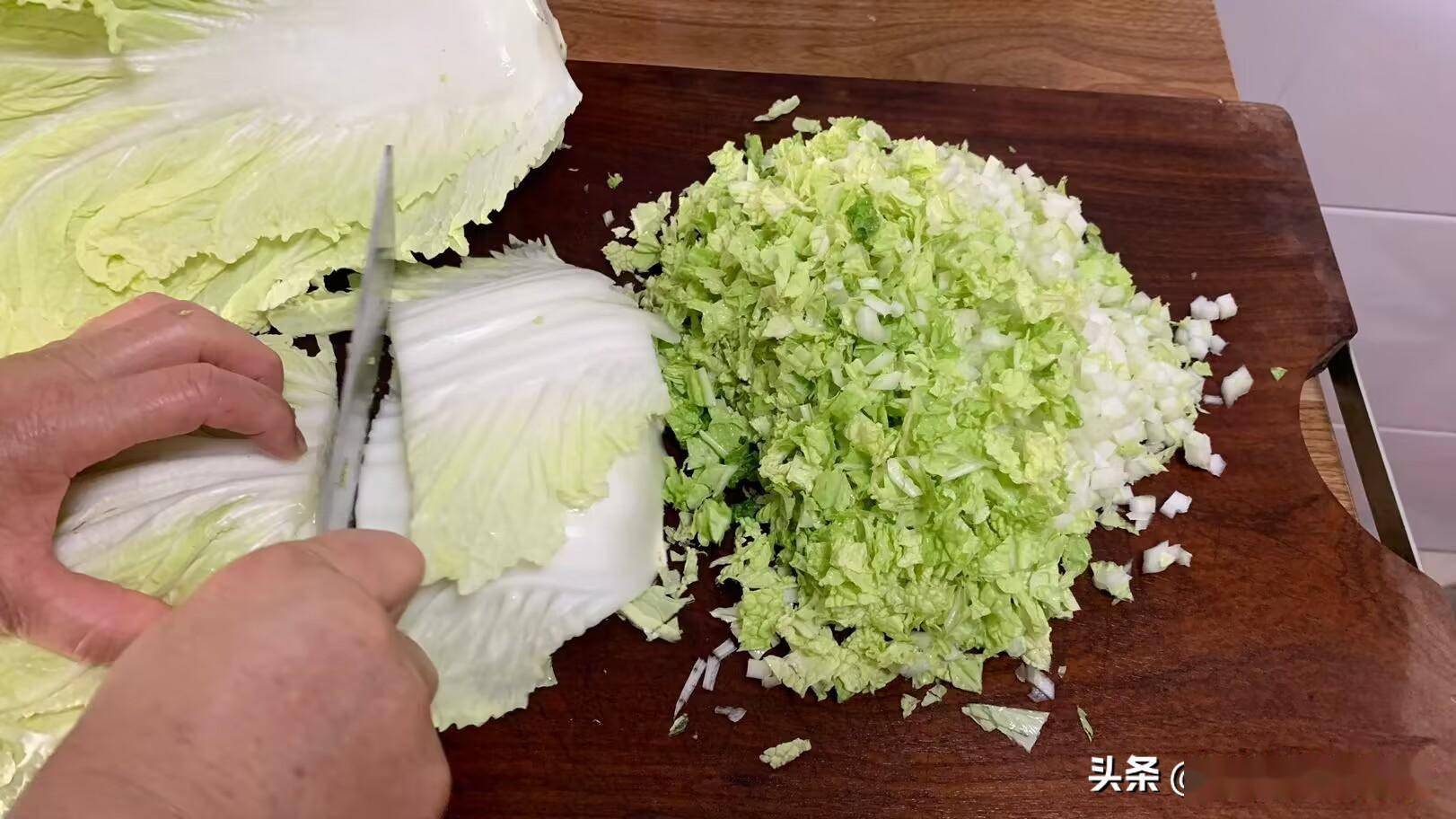 厨房台面上摆放着切好的白菜段,部分已入锅炖煮,蒸汽升腾,旁边有调料碗和木铲,展现家庭烹饪的真实场景 白菜在厨房中的烹饪场景