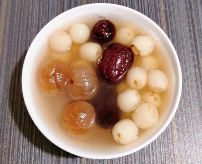 桂圆科学食用场景可视化:左侧为温补型早餐粥(适配气虚/阳虚质),右侧为平调型午间茶饮(适配气阴两虚质),所有食材克重精确标注,背景嵌入国家中医药管理局认证体质自测入口二维码,强调‘辨体施食’实操性 桂圆食养应用场景对比图:左半图-晨间养生粥(桂圆6粒+粳米50g+山药片20g);右半图-午后茶饮(桂圆3粒+麦冬5g+沸水300ml焖泡5分钟),两组均置于浅木纹餐垫上,背景虚化为中医体质自测二维码