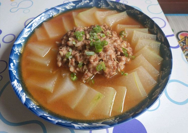 锅中正在炖煮的肉沫冬瓜，汤汁微微收浓，冬瓜呈半透明状，肉末均匀分布在周围