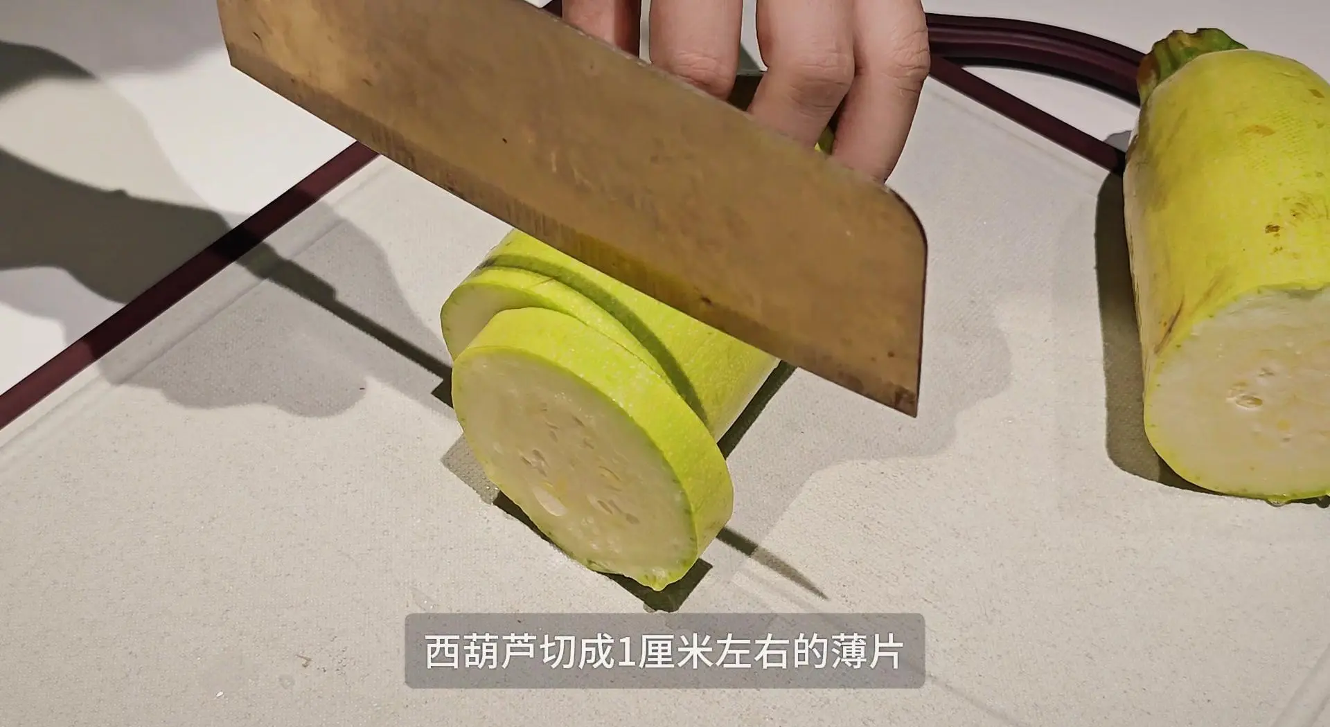 专业级西葫芦预处理现场图:清晰展示斜刀切菱形片的标准厚度(3mm)、厨房纸自然吸水过程、以及瓜瓤刮除后的洁净断面,强调‘不揉挤、只静置’的操作细节 西葫芦切配与控水步骤特写:砧板上整齐排列的翠绿菱形西葫芦片,下方垫三层吸水厨房纸,纸面微潮但无积水,旁边放置小碗盛放刮出的浅色瓜瓤