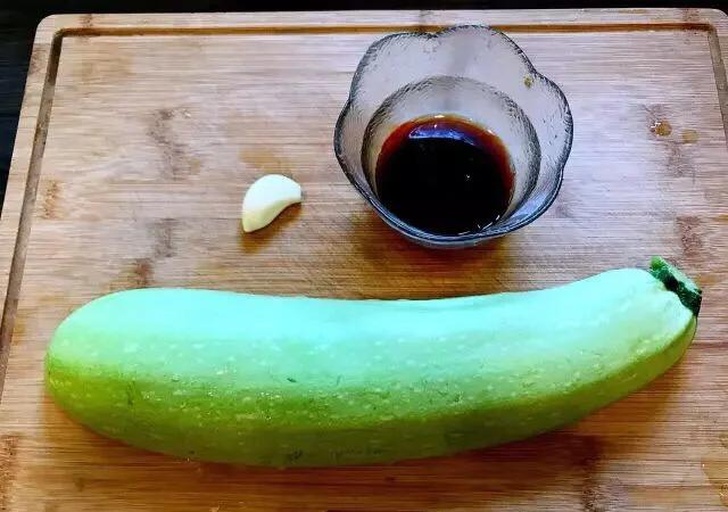 新鲜的西红柿和西葫芦摆放在案板上,旁边有大蒜和生姜 西红柿与西葫芦的食材搭配图