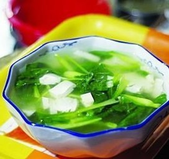 一碗由切块土豆、胡萝卜、洋葱炖煮而成的清淡蔬菜汤，汤色清亮，配有新鲜欧芹碎点缀，盛于白色瓷碗中，背景为浅灰色厨房台面