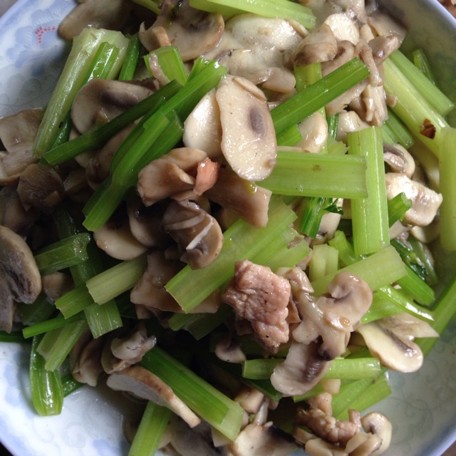 正在翻炒蘑菇与芹菜的锅具特写