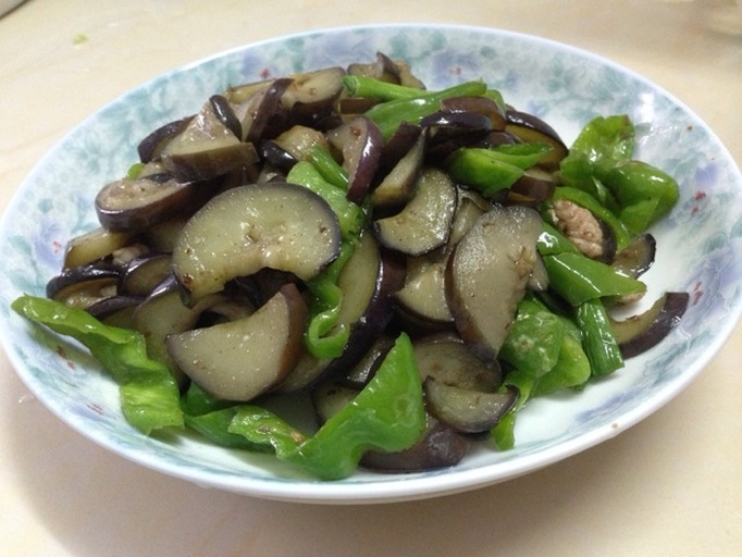高清成品图:红椒炒茄子装盘效果,突出茄块焦边质感、红椒鲜艳色泽、整体油润不泛水光,体现‘脆嫩不腻’核心卖点 红椒炒茄子成品特写:深紫茄块油亮微焦,鲜红椒片饱满脆亮,锅气十足,表面可见细密油光与隐约葱段,盛于青花瓷盘中