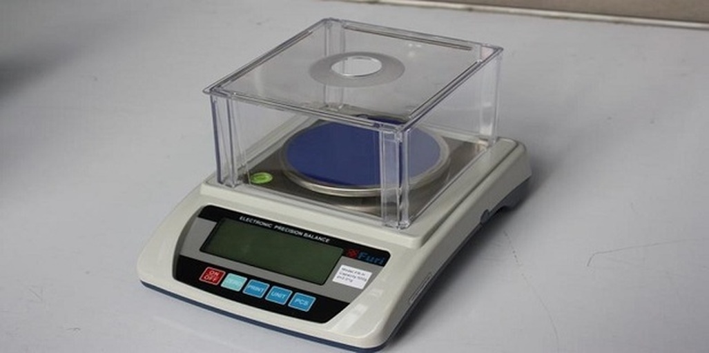 实验人员使用电子天平称量1000粒精选花生仁,背景为农业科研实验室工作台,桌上摆放有样品袋、记录本和刻度盘,展示标准化测量流程 花生千粒重测量示意图