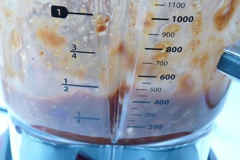 厨房场景实拍：电子秤显示屏特写（清晰显示'100.0 g'），秤盘上放置刚去皮切块的紫薯；旁边摆放标尺（显示5cm刻度）、一把不锈钢汤匙、一枚鸡蛋作参照物