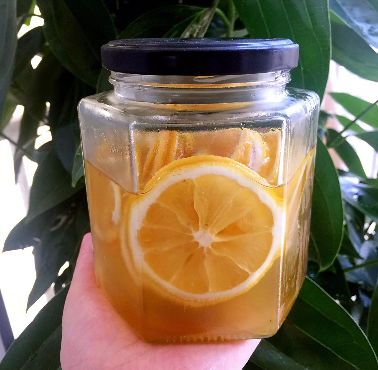 一位女性从冰箱中取出白糖泡柠檬罐准备冲饮