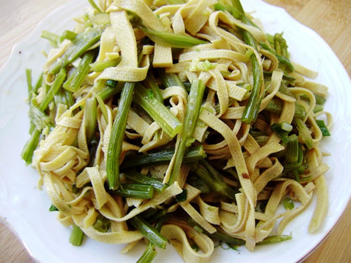 尖椒豆皮标准备料图:尖椒切菱形片、豆皮划格切细条、蒜末现剁,三者分置,体现食材处理精度 尖椒豆皮备料特写:砧板上整齐摆放翠绿尖椒菱形片、浅米黄豆皮细条、金黄蒜末,三者色泽分明,背景为木质料理台