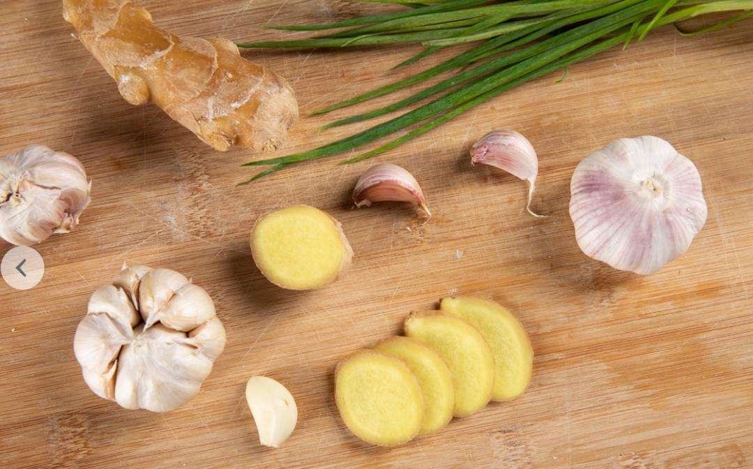 新鲜翠绿的蒜薹与猪肉摆放在案板上