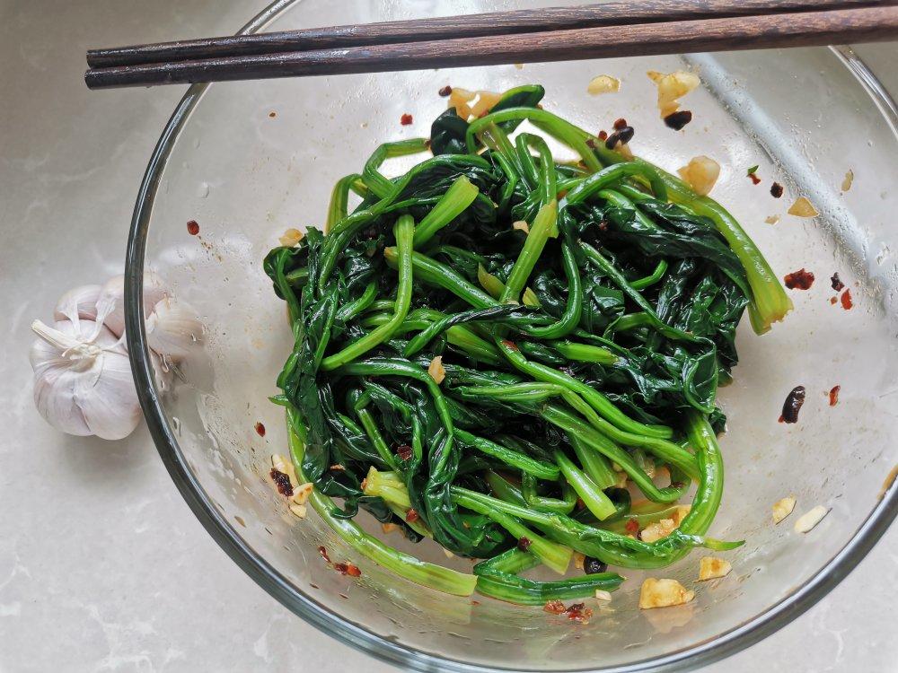 一碗调好味的蒜香菠菜特写，表面泛着油光并点缀蒜末