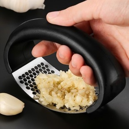 不锈钢压蒜器压制新鲜蒜瓣特写