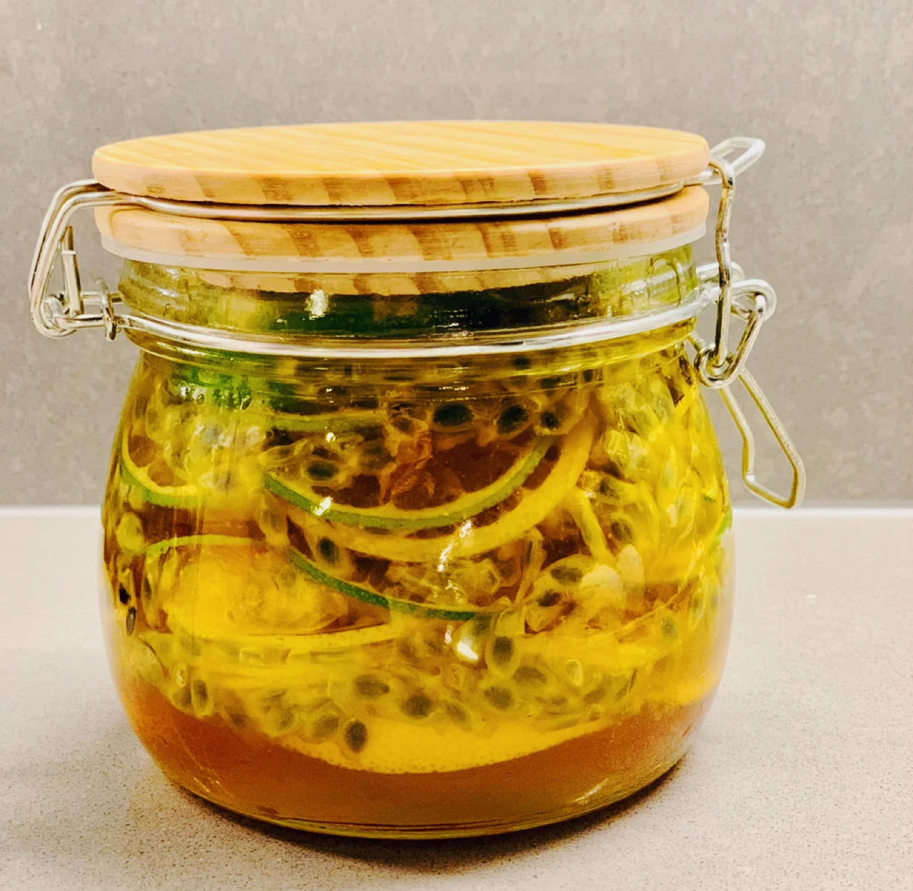 黄金百香果蜂蜜柠檬水成品图,玻璃杯中装有冰镇饮品,果肉清晰可见,杯边装饰柠檬片,清新诱人 黄金百香果蜂蜜柠檬水成品图