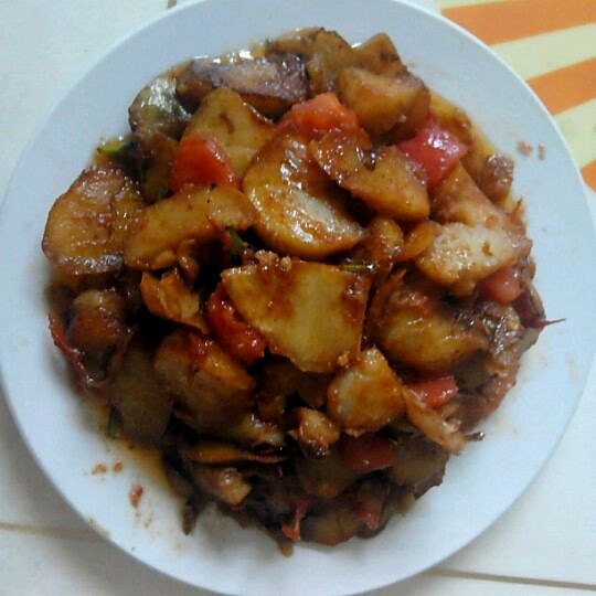高清俯拍:呈现理想火候下的番茄土豆片成品——土豆片保持柔韧口感(非软烂),番茄汁呈浓亮红褐色(非暗沉),油星均匀分布(证明脂溶性营养素充分溶出),无水分积聚或干焦现象,体现精准烹饪控制 番茄土豆片成品特写:琥珀色土豆片半透明、边缘微韧,包裹浓稠番茄红汁,表面浮有细小油星,无焦黑斑点,盛于浅灰釉粗陶盘中,顶部撒微量新鲜欧芹碎